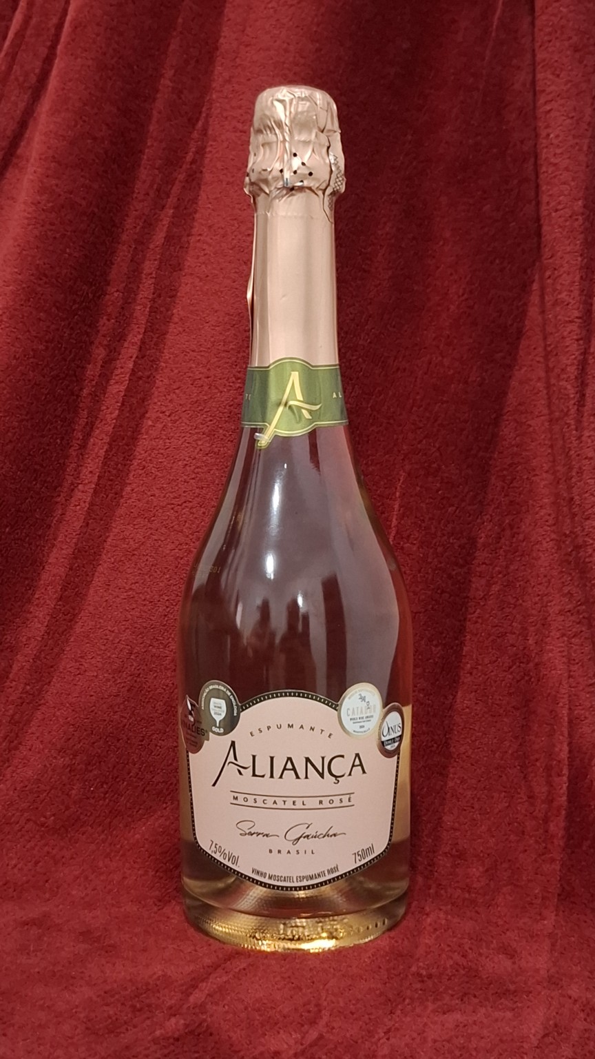 Garrafa de Aliança Moscatel Rosé em fundo vermelho