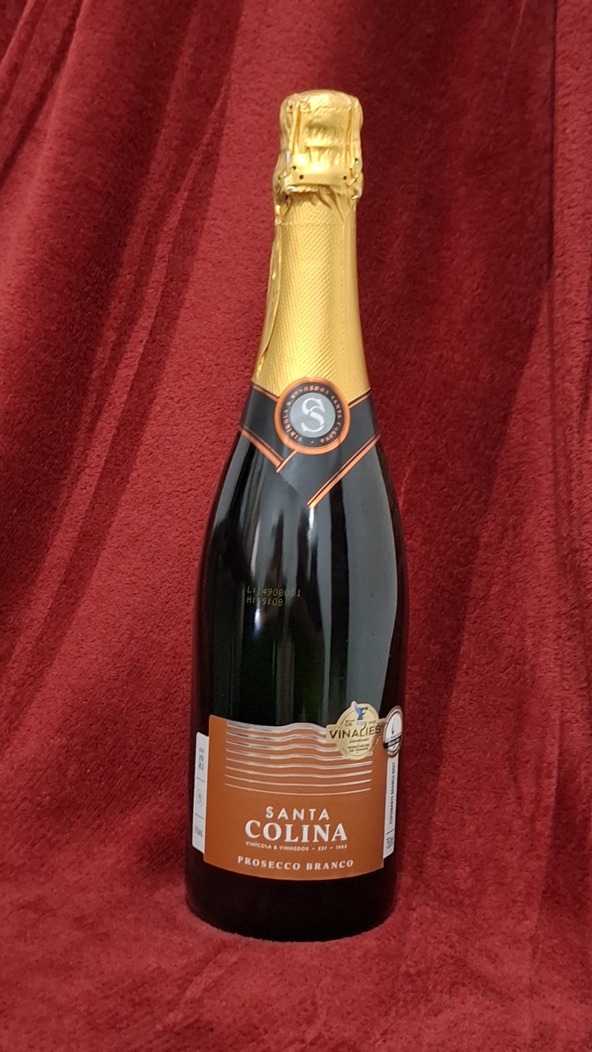 Garrafa de Santa Colina Prosecco Brut em fundo vermelho